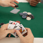 "People playing poker at a table, focusing on cards and chips"
